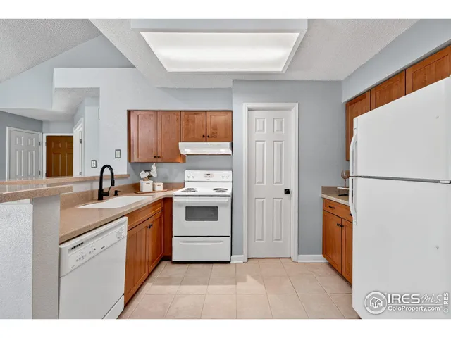 a kitchen with stainless steel appliances granite countertop a refrigerator sink and stove