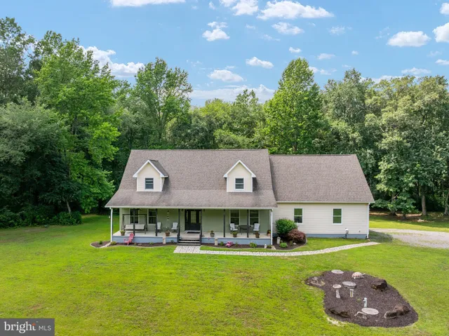 a front view of house with garden and trees