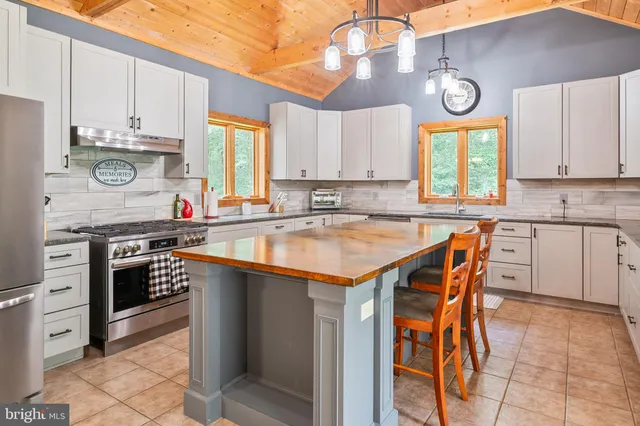 a living room with stainless steel appliances kitchen island a sink and cabinets
