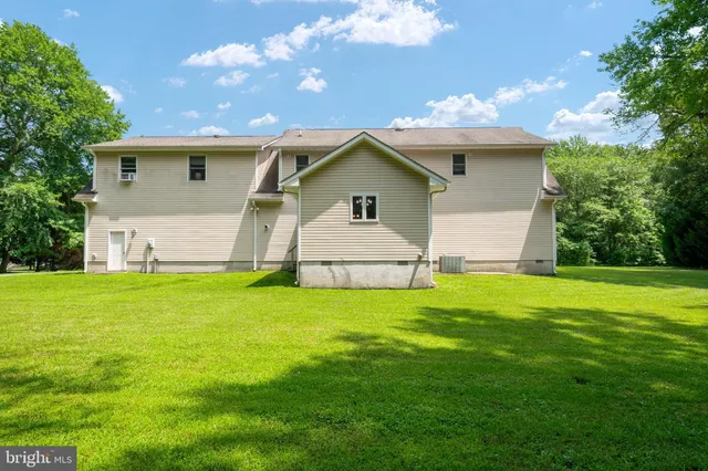 a view of a green yard with an outdoor seating and trees