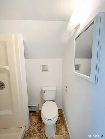 a bathroom with a toilet and a mirror