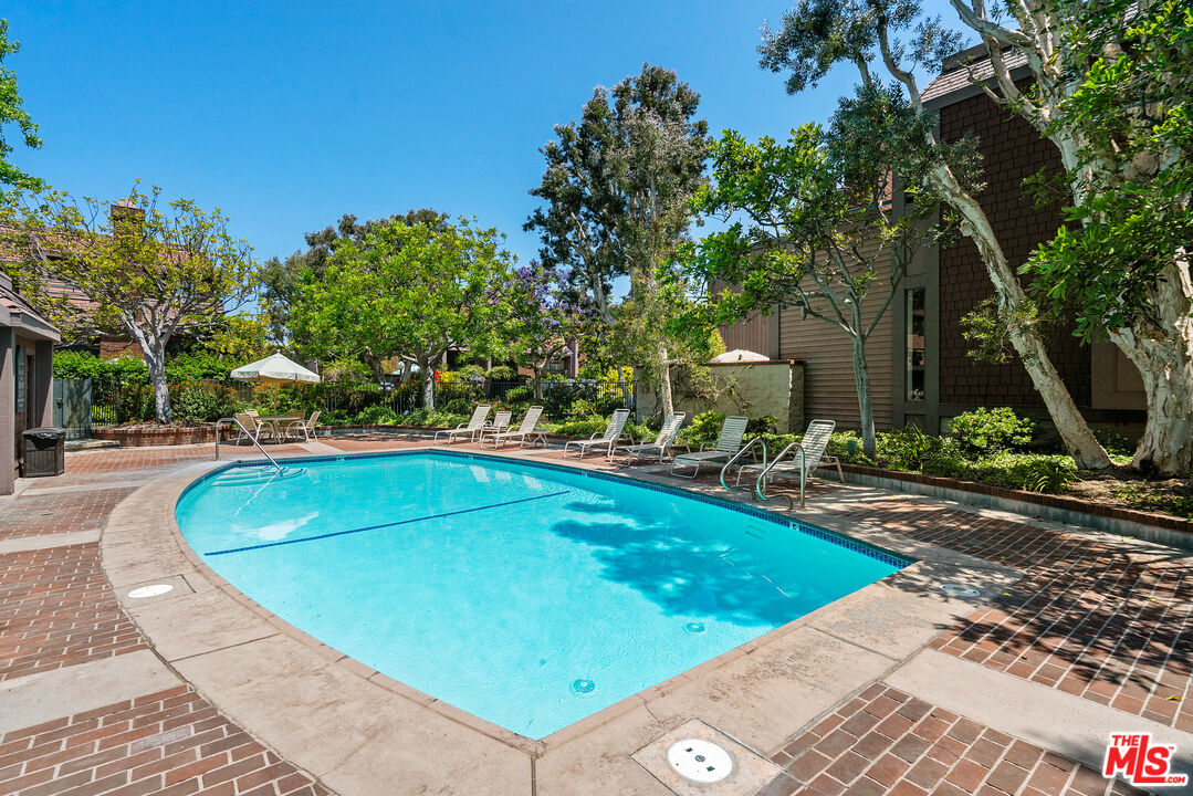 4421 Alla Road, Unit 3 Marina del Rey, CA 90292 - Photo 27 of 31 a view of a swimming pool with lawn chairs under an umbrella