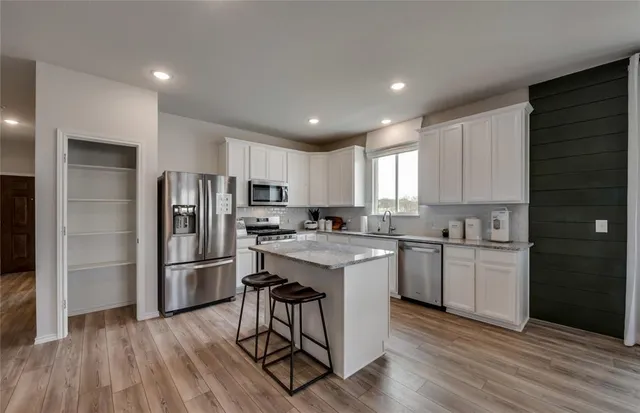 a kitchen with refrigerator cabinets and wooden floor