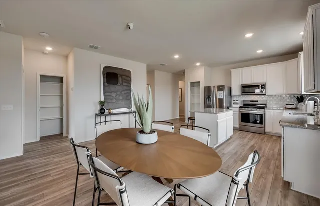 a kitchen with a table chairs microwave and cabinets