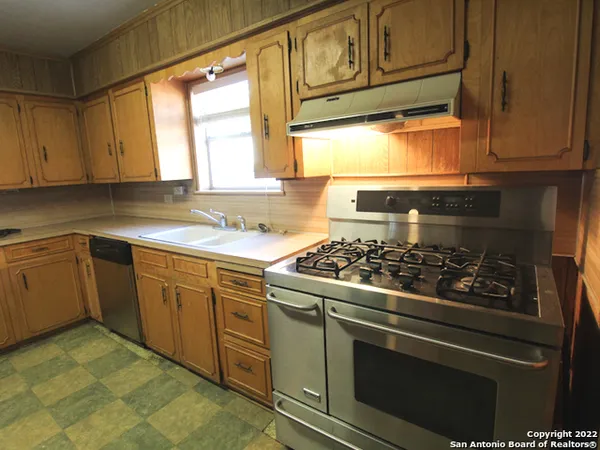 a kitchen with cabinets appliances and a window