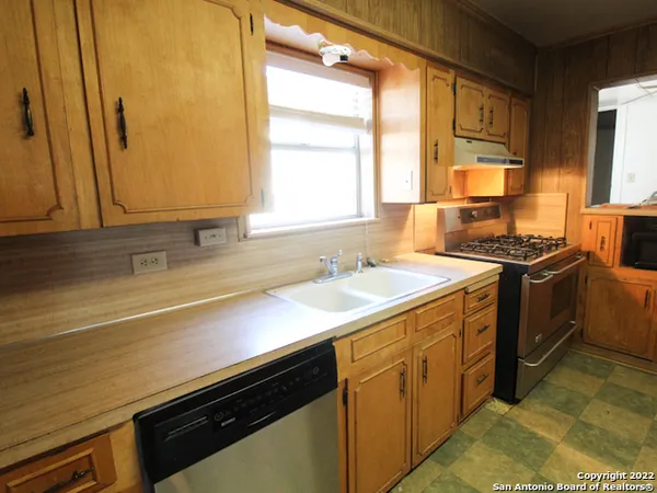 a kitchen with a sink stove and cabinets