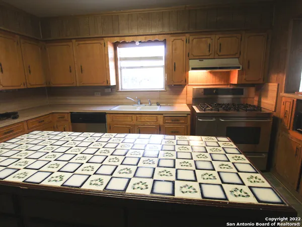 a kitchen with a sink and a stove top oven