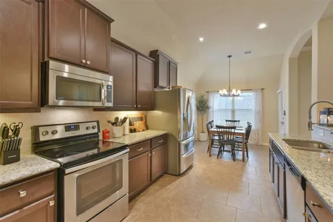 a kitchen with stainless steel appliances granite countertop a sink stove and microwave