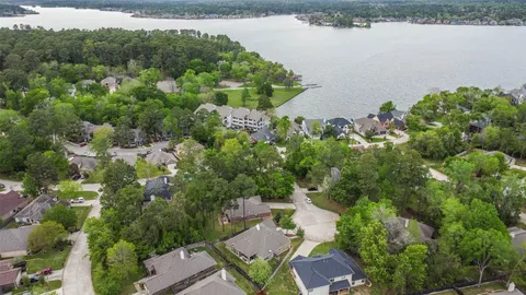 an aerial view of a house with a yard and lake view