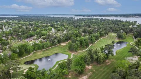 an aerial view of a residential houses with outdoor space and trees