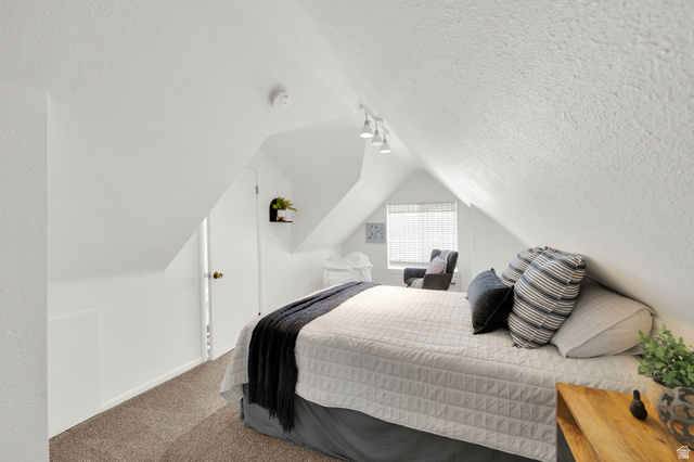 446 South 300 East Provo, UT 84606 - Photo 25 of 32 Attic bedroom featuring sloped ceilings, white textured walls, and track lighting