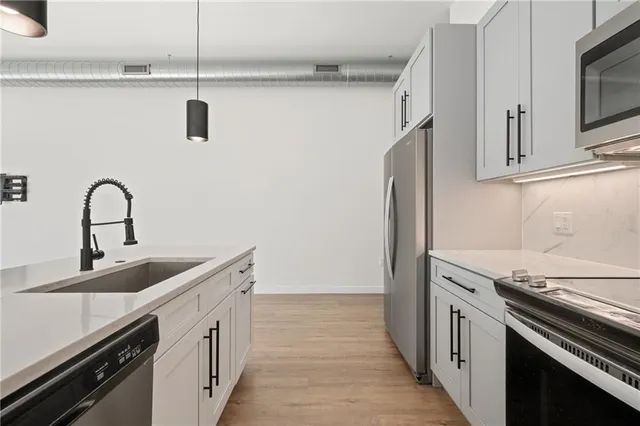 a kitchen with stainless steel appliances and white cabinets