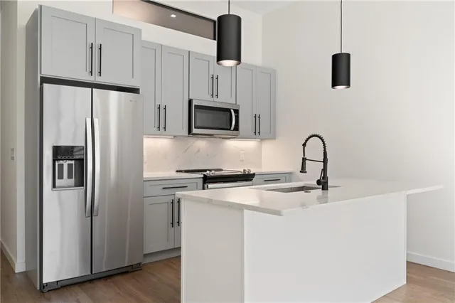 a kitchen with stainless steel appliances a refrigerator sink and microwave