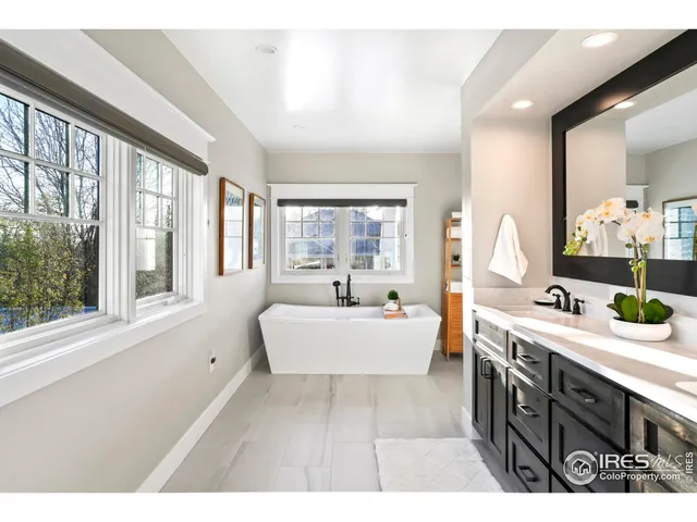 a spacious bathroom with a large tub sink and mirror