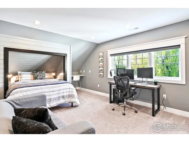 a bedroom with a bed and large windows