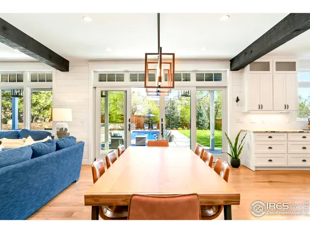 a living room with furniture large windows and wooden floor