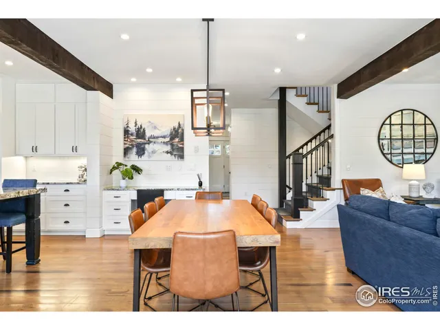 a living room with furniture a dining table with wooden floor chairs and kitchen view