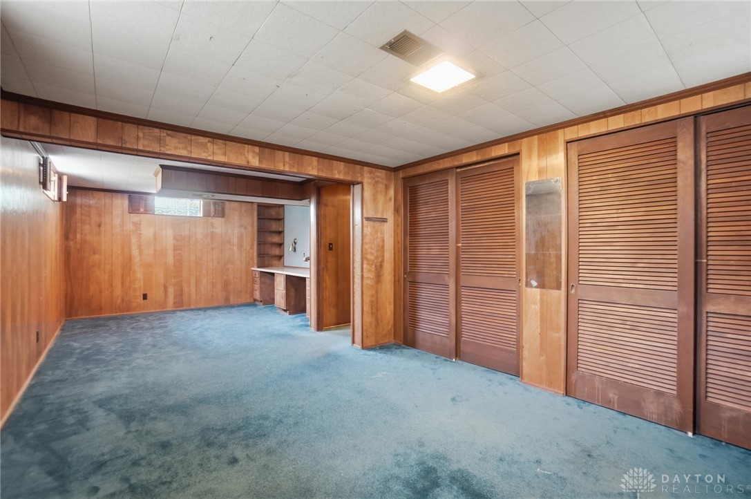 6119 Flemington Road Dayton, OH 45459 - Photo 45 of 76 This versatile basement offers a carpeted area with wood paneling, perfect for a recreation room or home office.