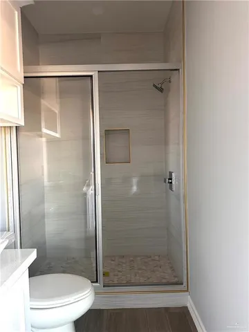 a bathroom with a shower a toilet and a sink