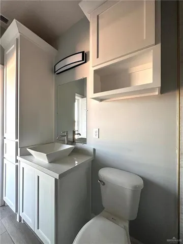 a bathroom with a granite countertop toilet sink and mirror