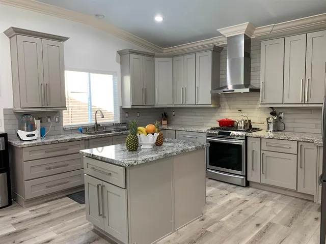 a kitchen with granite countertop a sink stove and cabinets