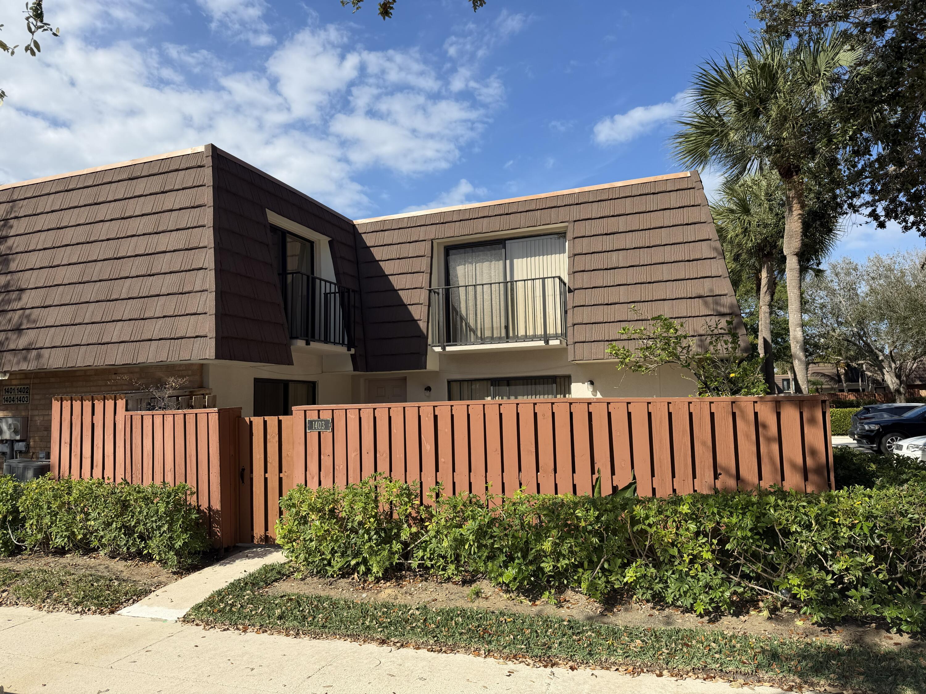 1403 14th Court Jupiter, FL 33477 - Photo 1 of 25 a front view of a house with garden