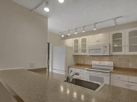 1403 14th Court Jupiter, FL 33477 - Photo 6 of 25 a kitchen with granite countertop a stove and a sink