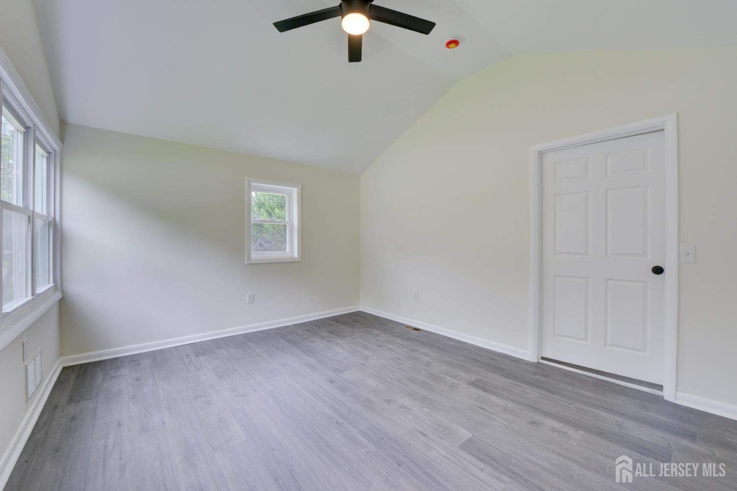 6 Main Street Helmetta, NJ 08828 - Photo 7 of 27 an empty room with wooden floor chandelier fan and windows