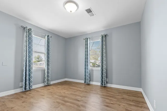 an empty room with windows and closet