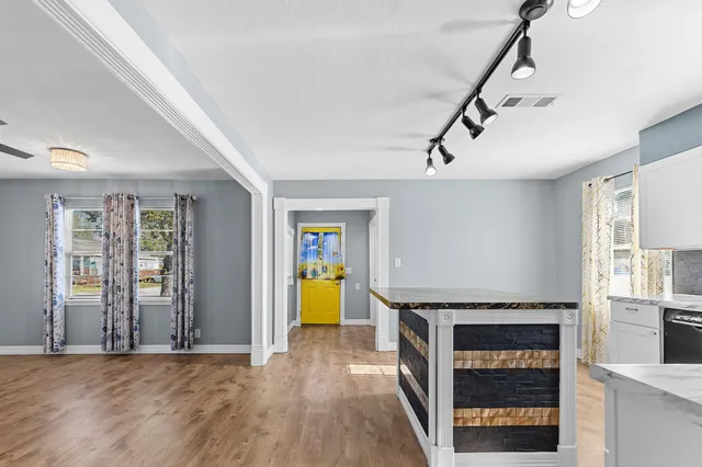 a view of a livingroom with wooden floor and a ceiling fan