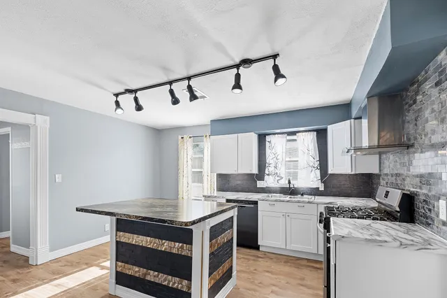 a kitchen with a stove sink and cabinets