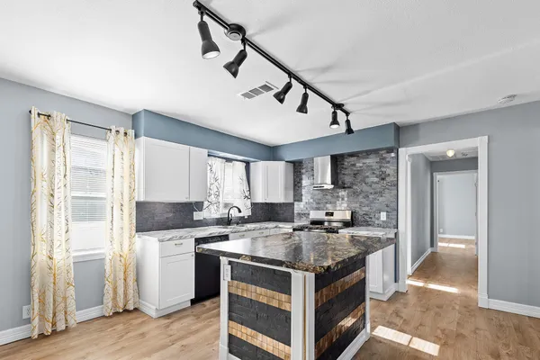 a kitchen with a stove a sink and a refrigerator