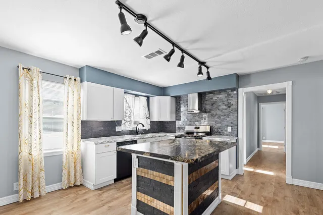 a kitchen with a stove a sink and a refrigerator