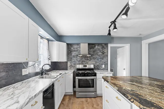a kitchen with stainless steel appliances granite countertop a sink stove and cabinets