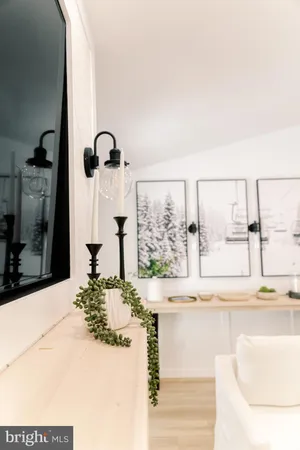 a table with chairs and a vase of flowers