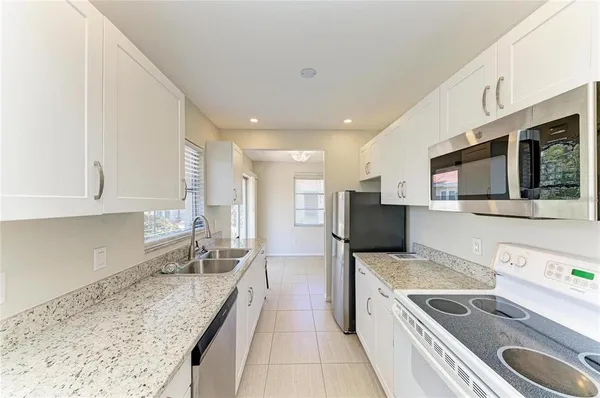 a large kitchen with stainless steel appliances granite countertop a sink and a stove