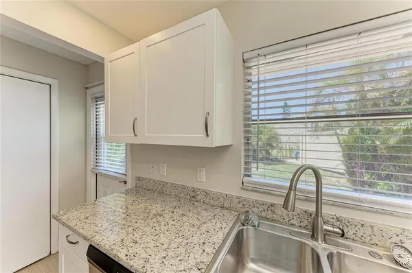 a kitchen with granite countertop a sink and a wooden floor