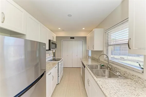a kitchen with stainless steel appliances granite countertop a sink refrigerator and cabinets