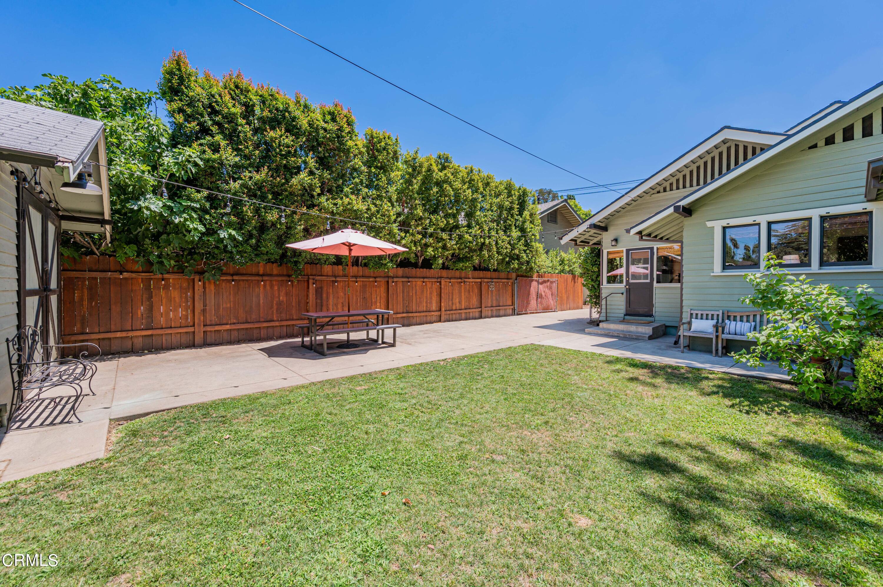 1265 North Wilson Avenue Pasadena, CA 91104 - Photo 27 of 48 a view of a backyard with table and chairs potted plants and wooden fence