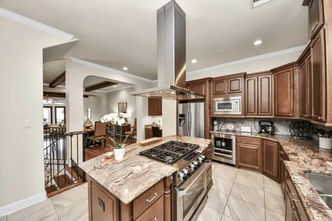 a kitchen with a stove a sink dishwasher and a refrigerator with wooden floor