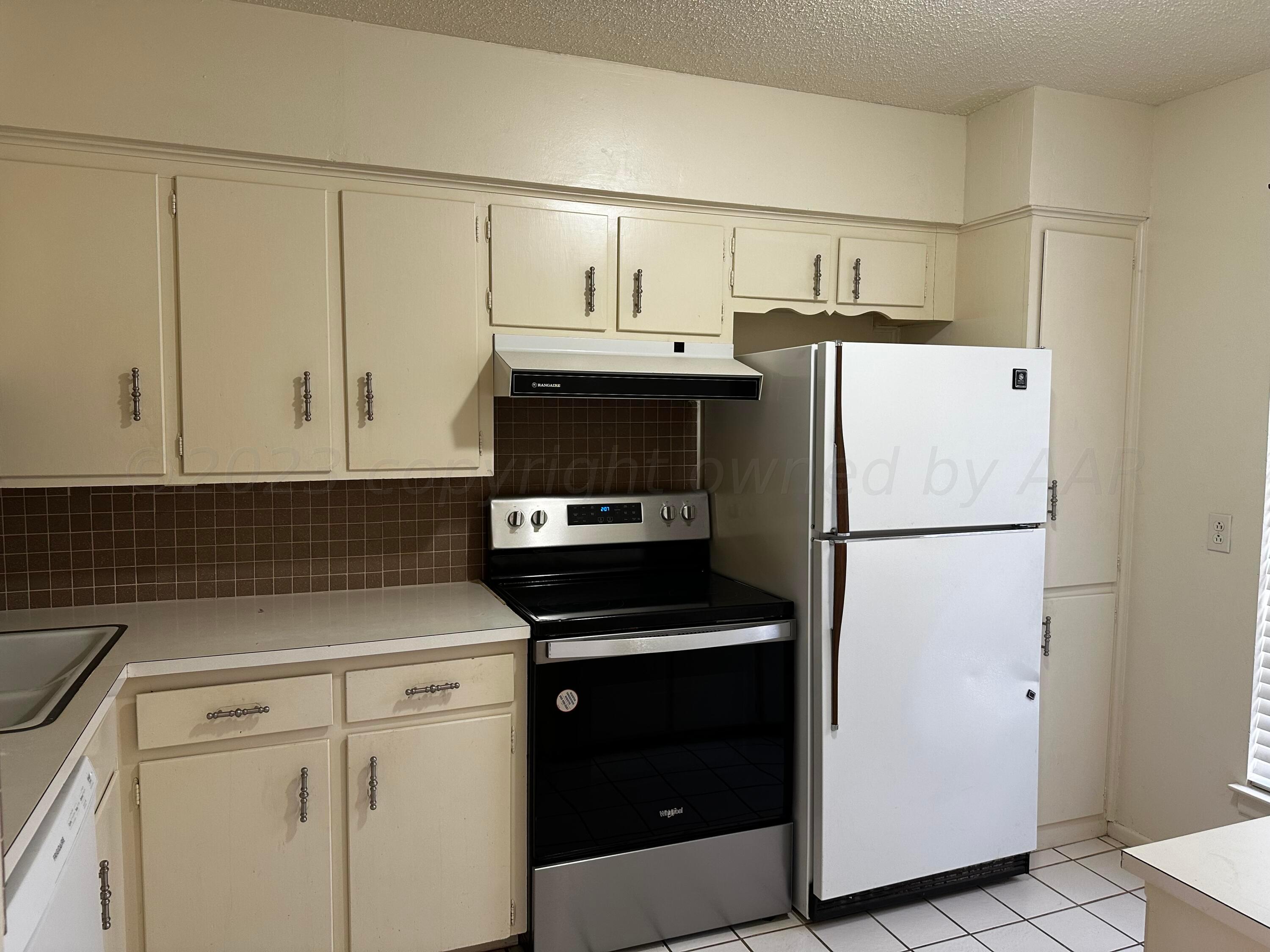 3219 Villa Place Amarillo, TX 79109 - Photo 11 of 13 a kitchen with a refrigerator sink and cabinets