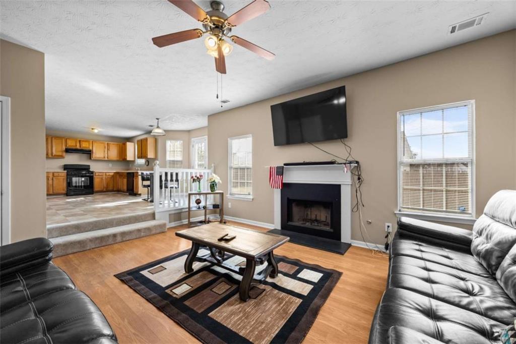 100 Adelaide Drive Covington, GA 30016 - Photo 12 of 33 a living room with furniture a fireplace and a flat screen tv