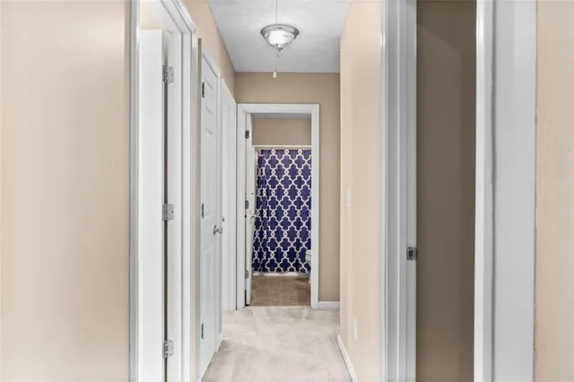 a view of a hallway with closet and bathroom