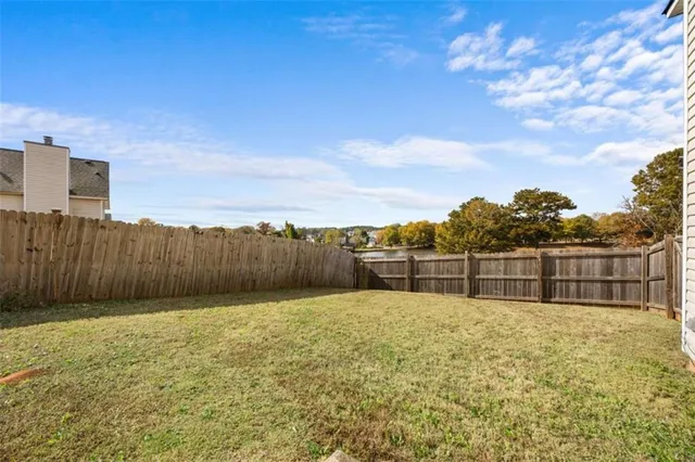 a view of swimming pool with a yard and wooden fence