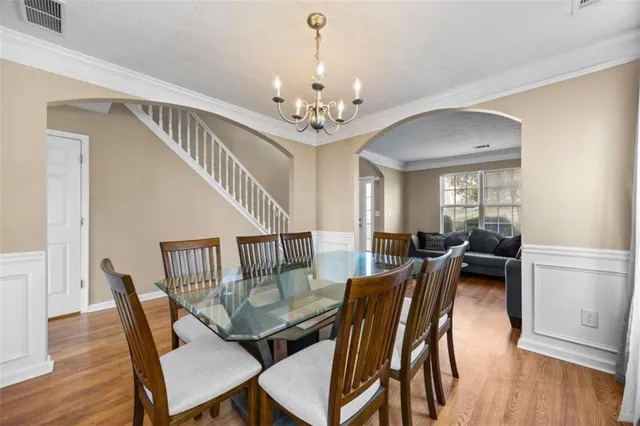 a view of a dining room with furniture wooden floor and chandelier