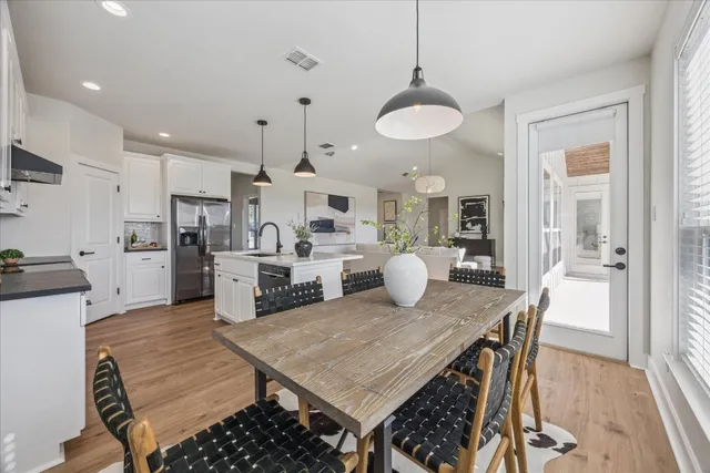 a kitchen with stainless steel appliances granite countertop a kitchen island a stove a table and chairs in it