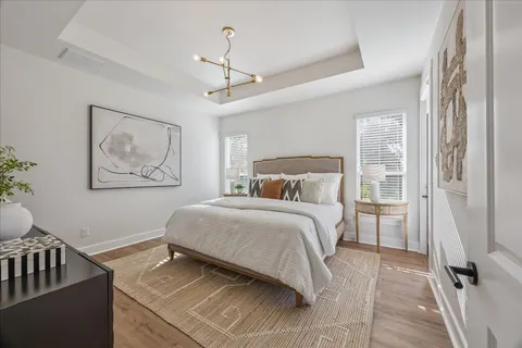 a bedroom with a large bed and a chandelier