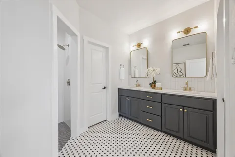 a spacious bathroom with a double vanity sink a mirror and a
