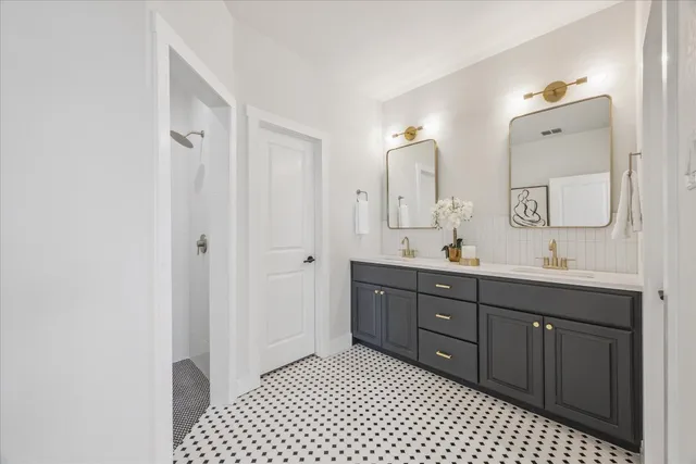 a spacious bathroom with a double vanity sink a mirror and a