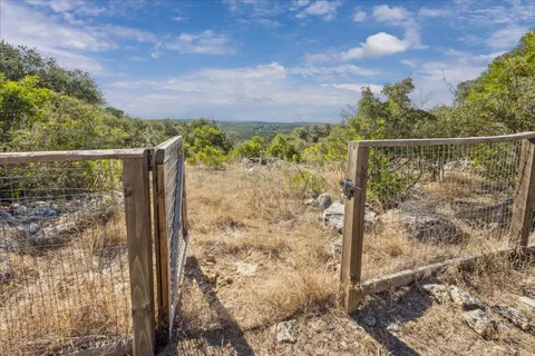 a view of a yard with wooden fence